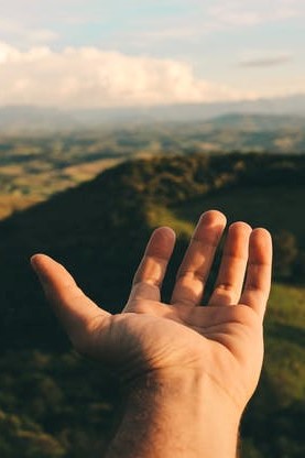 Image of a hand over a view of hills